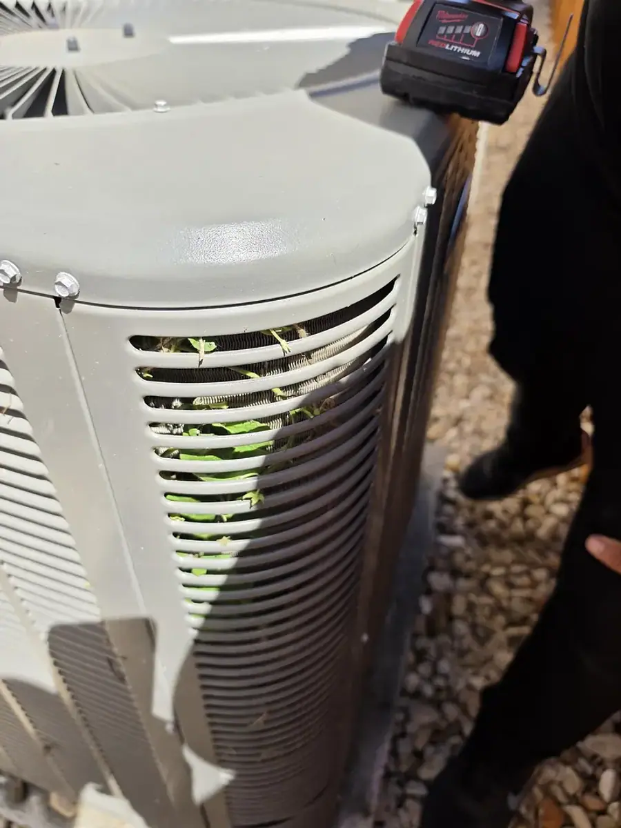 Close view of the outdoor coil fins on a white condensing unit set on gravel.