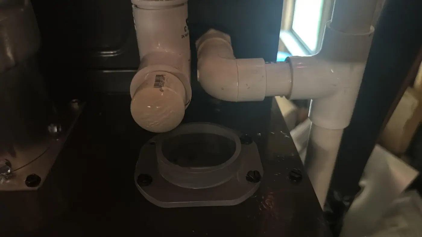 PVC condensate piping and a trap assembly beneath an air handler.